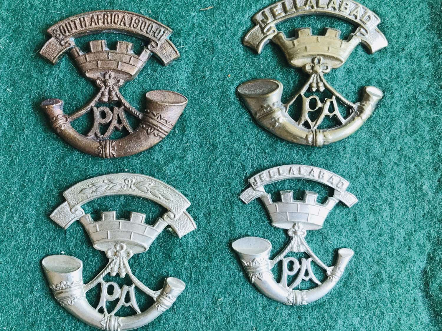 A collection of 12 Somerset light infantry cap badges